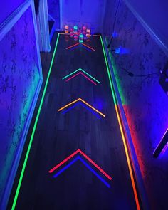 a long hallway with neon lights on the floor