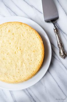 a cake sitting on top of a white plate next to a knife and fork,