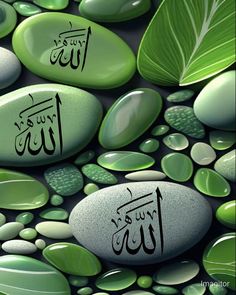 some green rocks and leaves with arabic calligraphy on them, all surrounded by water droplets