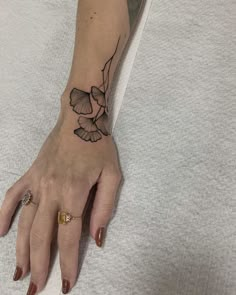 a woman's hand with a small bird tattoo on the left side of her arm