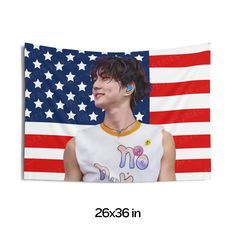 a man with ear buds standing in front of an american flag wall hanging on a wall