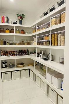 an organized pantry with white shelving and bins