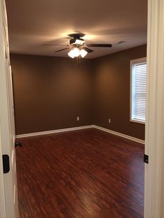 an empty room with hard wood floors and ceiling fan