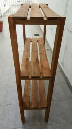 a wooden shelf sitting on top of a tiled floor