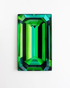 a green and black diamond on a white surface