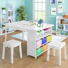 a child's table and chairs in a room with blue walls, wooden floors and white furniture