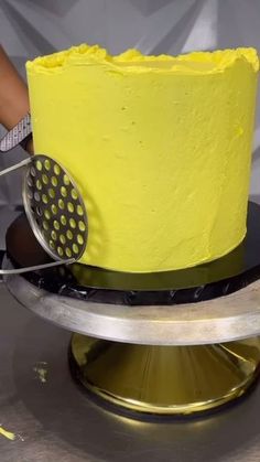 a yellow cake is being cut with a knife