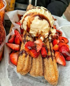 a waffle with ice cream and strawberries on the side sitting on a table