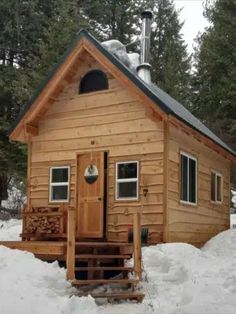 a small wooden cabin sitting in the snow