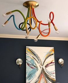 a chandelier hanging from the ceiling in a room with blue walls and artwork