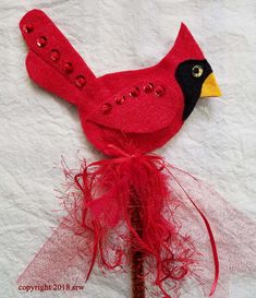 a red bird with black and yellow feathers on it's head sitting on a piece of paper