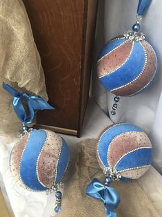 two blue and pink ornaments with bows on them