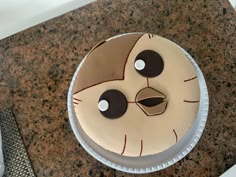 a cake decorated to look like a bird with eyes and nose shapes on it's face