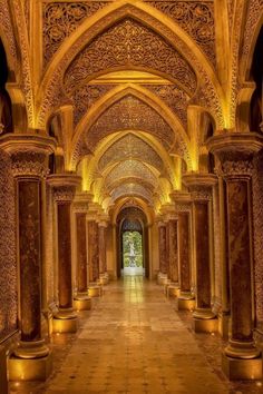 the inside of an ornate building with columns and lights on either side of the walkway