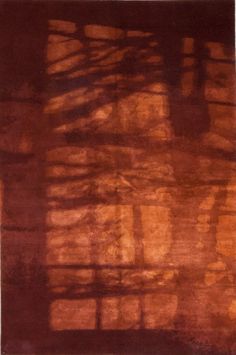 an orange and brown rug with trees casting shadows on it