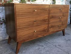 a wooden dresser sitting on top of a sidewalk