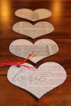 three heart shaped paper tags on a wooden table