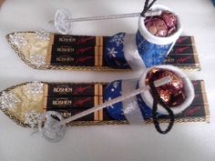 two skis with candy in them sitting on top of a white tablecloth covered table