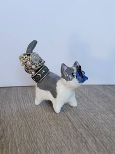 a cat figurine with a ring on it's head sitting on a table