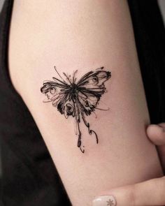 a woman's arm with a butterfly tattoo on the back of her left arm