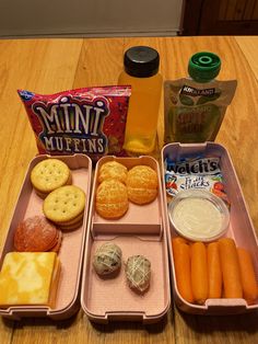 the lunch box is full of snacks, crackers, and juice on the table