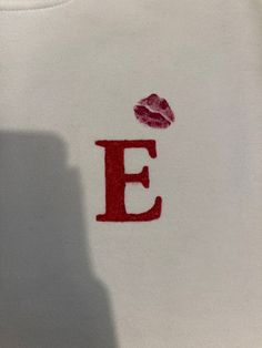 the letter e is printed on a t - shirt with lipstick imprinted on it