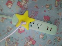 a yellow star shaped power strip sitting on top of a blue and white wallpaper