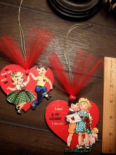 two valentine's day ornaments are sitting on a table