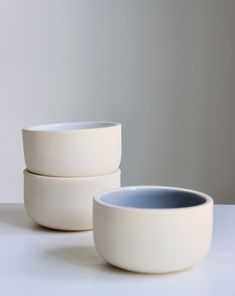 three white bowls sitting next to each other on a table