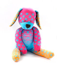 a blue and pink stuffed dog with polka dots on it's face sitting down