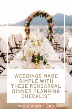 a table set up with white flowers and candles for a wedding dinner on the water