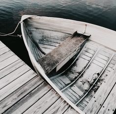 an old boat is tied up on the dock