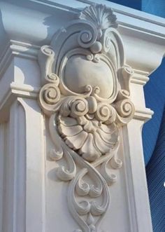 an ornate design on the side of a building with blue skies in the back ground