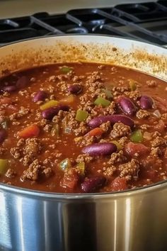 a pot filled with chili and beans on top of a stove