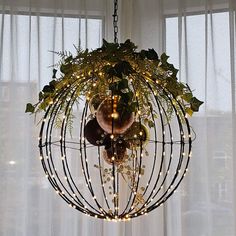 a chandelier with lights hanging from it's sides in front of a window