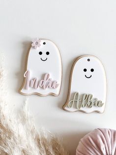 two decorated cookies with the words name and ghost on them