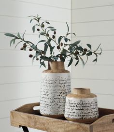 two vases with plants in them sitting on a tray