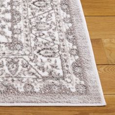 an area rug on the floor with wood floors in the background and light brown tones