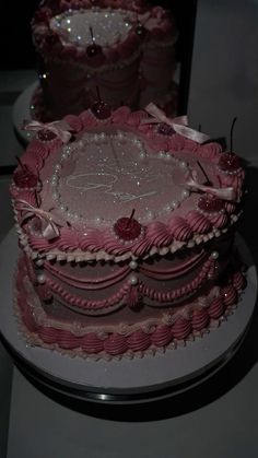 three tiered cake with pink frosting and decorations