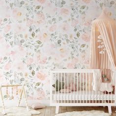 a baby crib in front of a floral wallpaper