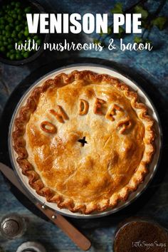 a pie with the word dad written on it next to some peas and other food