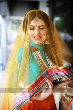 a woman in a green and yellow outfit with pearls on her head is smiling at the camera