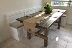 a wooden table with two benches and a potted plant on the bench next to it