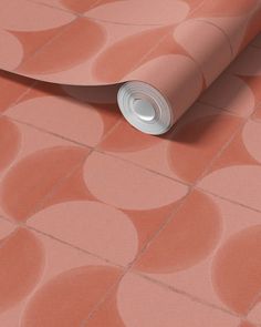 a pink wallpaper with circles on it and a roll of paper in the middle