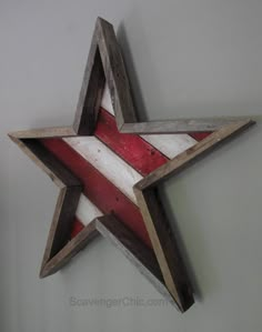 a red white and blue wooden star hanging on the side of a wall in a room