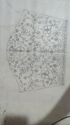 an embroidered umbrella with flowers and leaves on the outside is sitting on a piece of paper