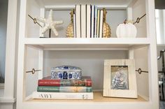 a shelf with books and pictures on it