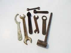 various wrenches and spanners are arranged on a white surface