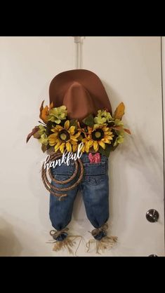 a cowboy hat and sunflowers are hanging on the wall