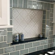 a kitchen with white and gray tile backsplash